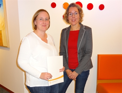 Carmen Jansen hält ihr druckfrisches Zertifikat als qualifizierte Tagespflegeperson in ihren Händen. 