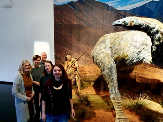 Foto neben einer Installation, die einen Maori bei der Jagd auf einen Moa zeigt