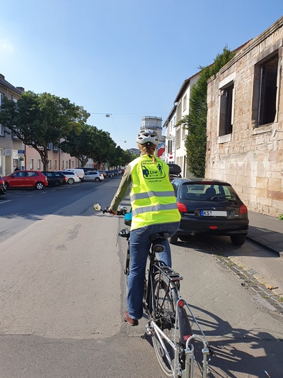 Fahrradfahrerin mit Warnweste der Stadt Kassel