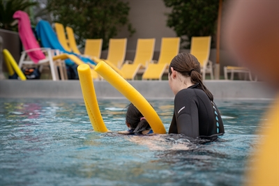 Angestellte des Bäderbetriebs helfen den Kindern, sich ans Wasser zu gewöhnen