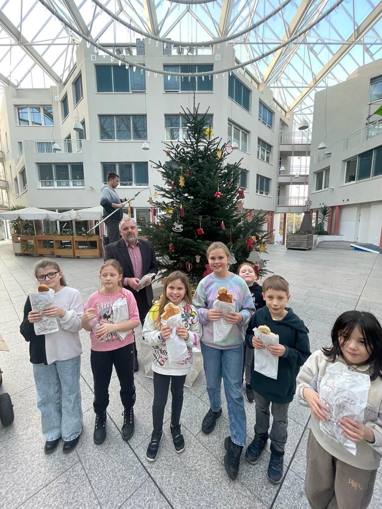 Kinder schmücken den Weihnachtsbaum im Rathaus